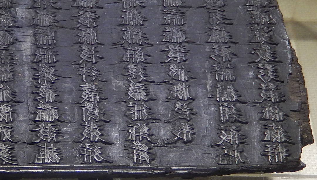 A stone tablet with  writing etched into it.