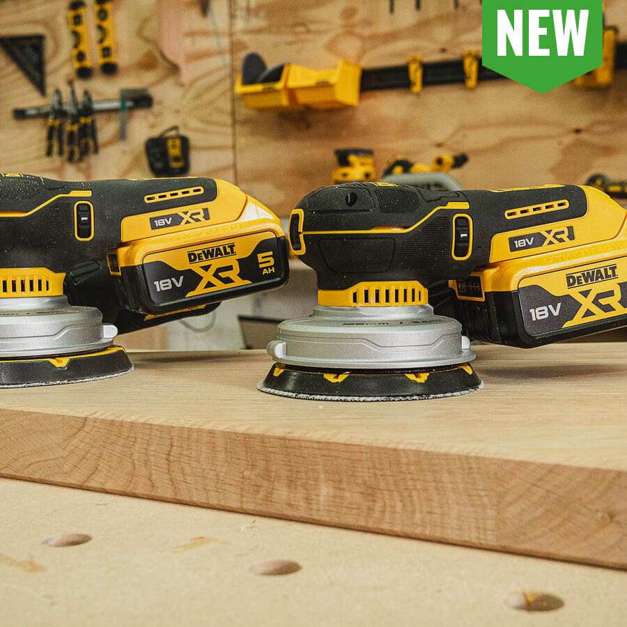 Three yellow and black sanders on wooden surface with a 