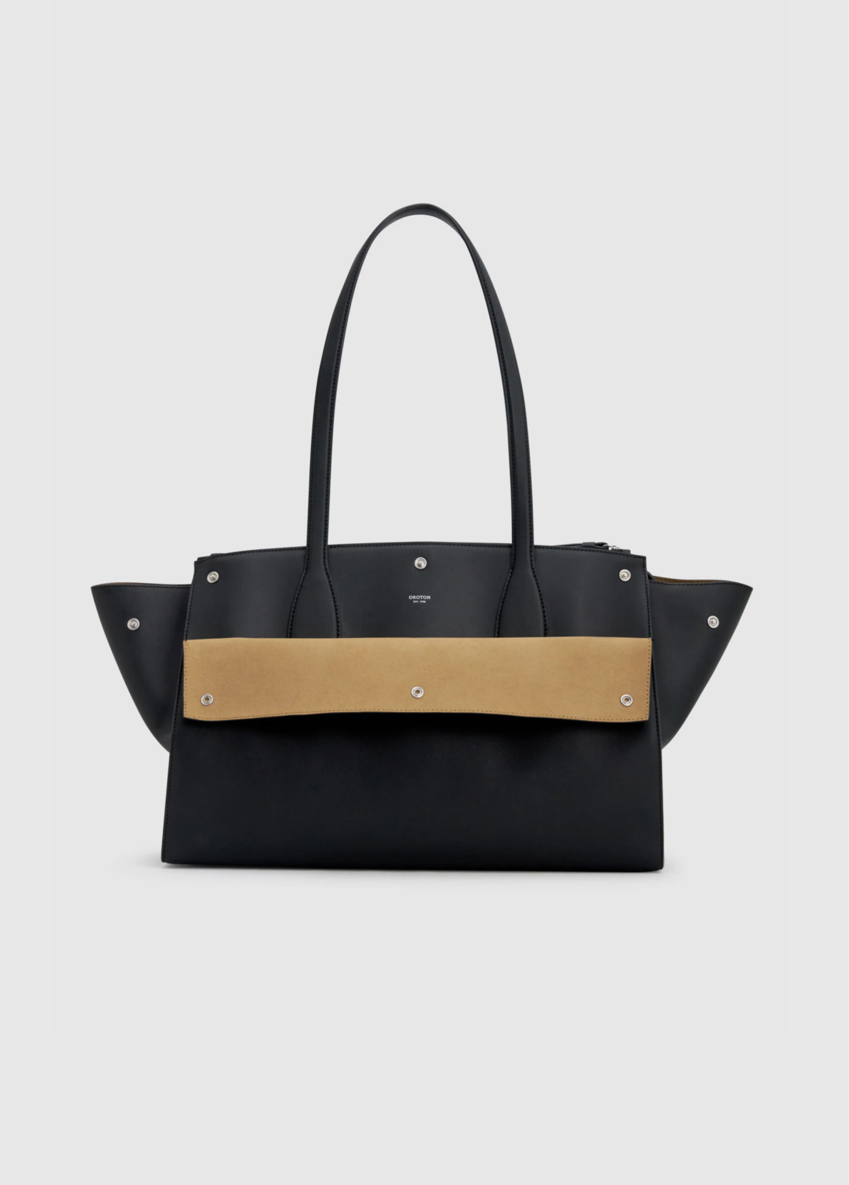 A black handbag with a tan strap and decorative studs.
