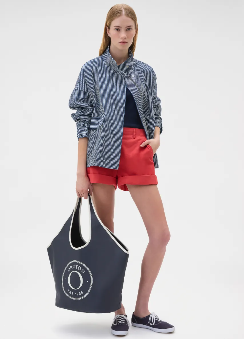 Young woman in casual outfit holding a tote bag.