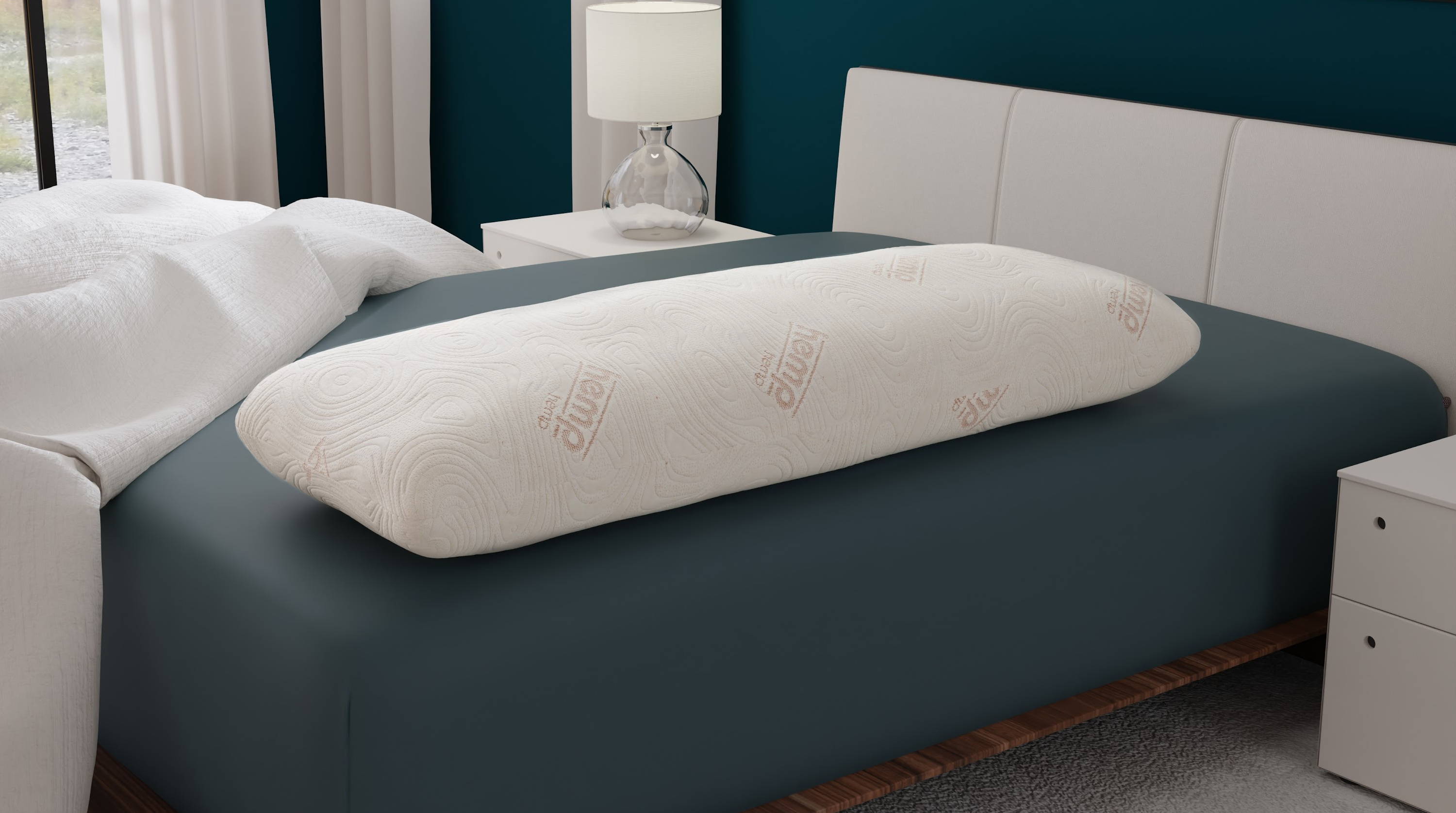 CBD and copper infused gel memory foam body pillow laying down longwise on a bed with a teal sheet.
