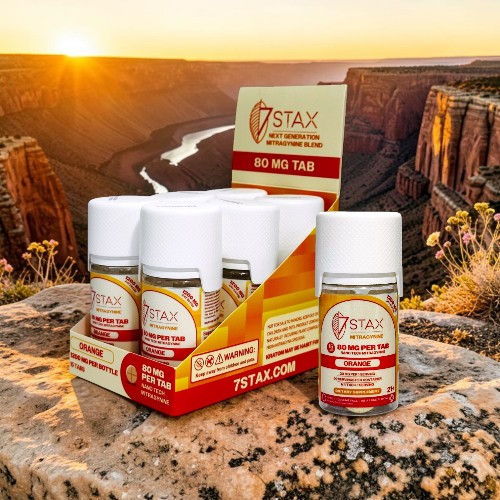 Five bottles of STAX energy supplement with canyon backdrop at sunset.