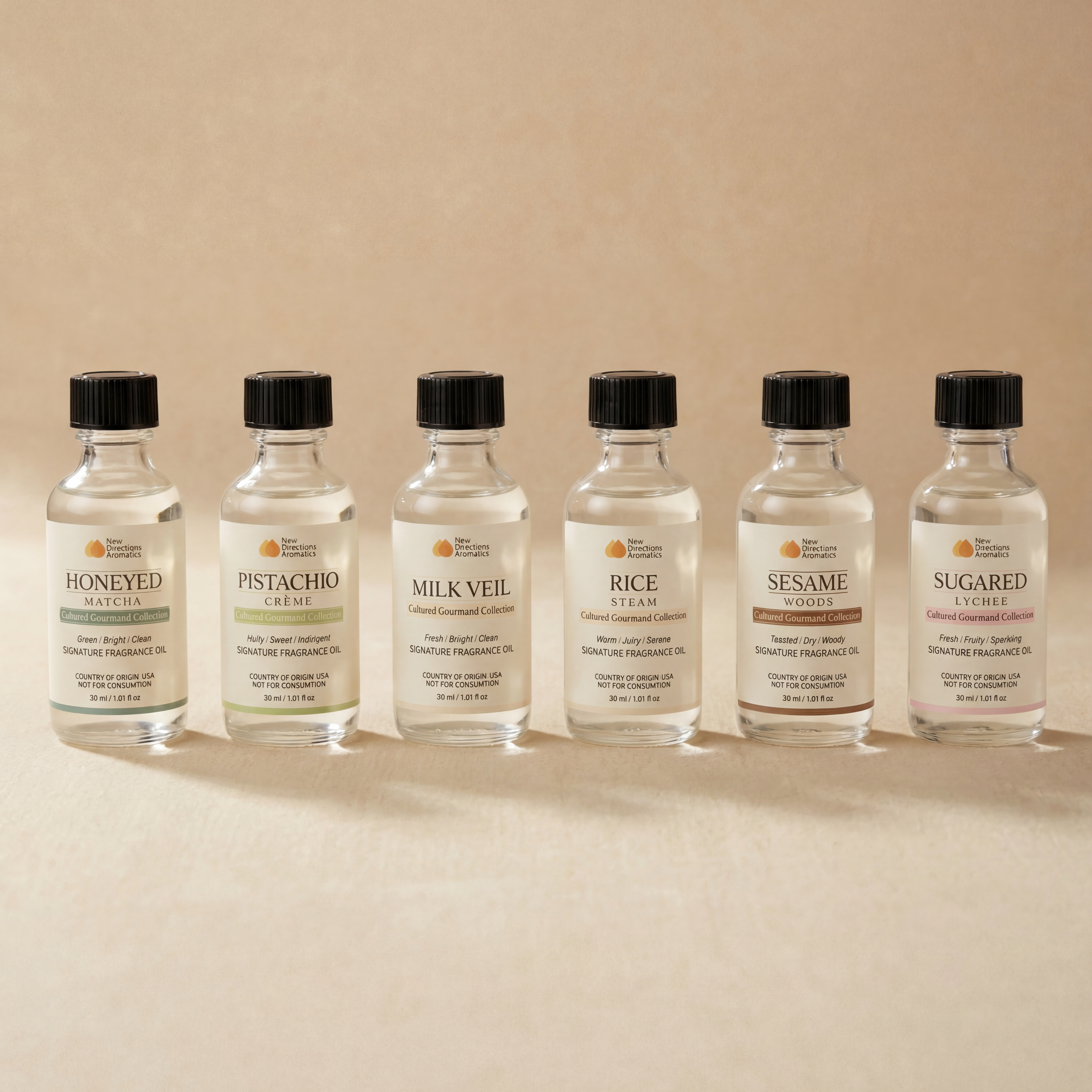 Bottles of clear liquids with black caps arranged in a row.