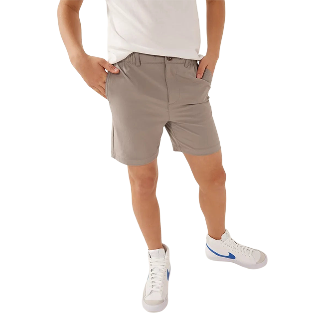 Person wearing gray shorts and white sneakers, hands on hips.