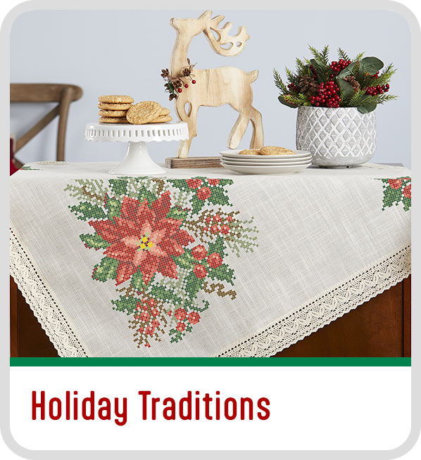 Table setting with holiday decorations, including a poinsettia tablecloth and reindeer figurine. Test Holiday Traditions