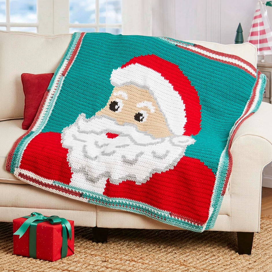 Graphgan blanket featuring Santa Claus design on a couch with a gift.