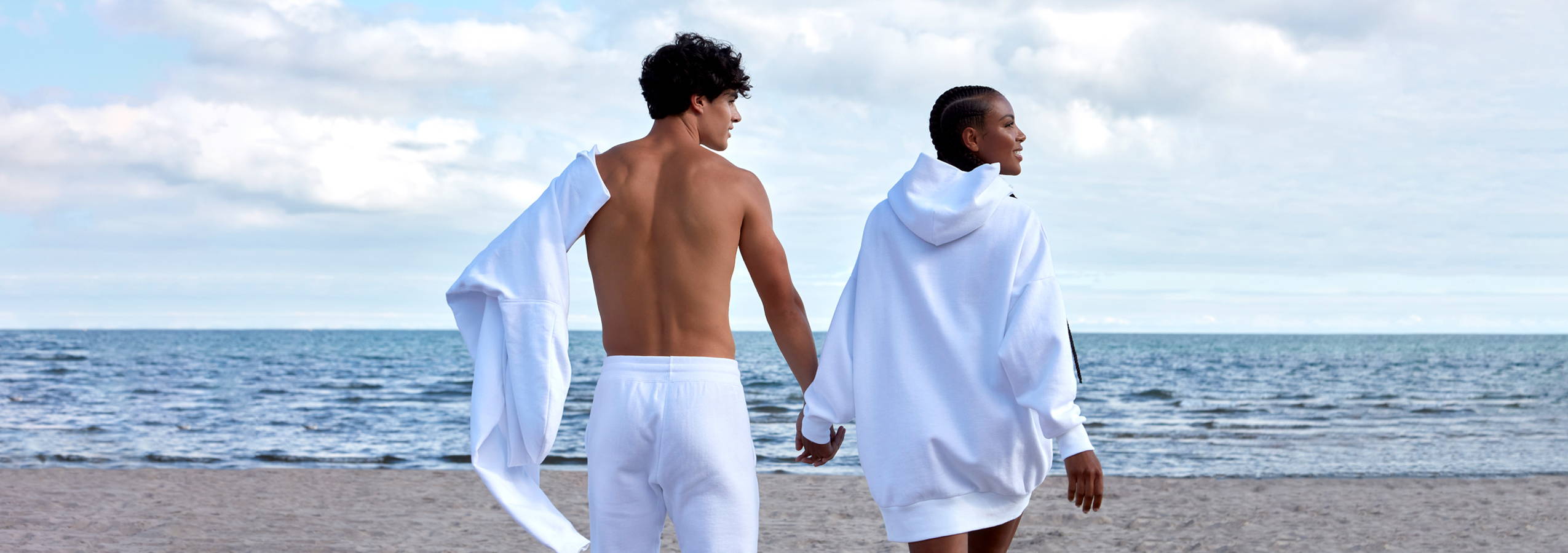 man and women model wearing white warm core on the beach