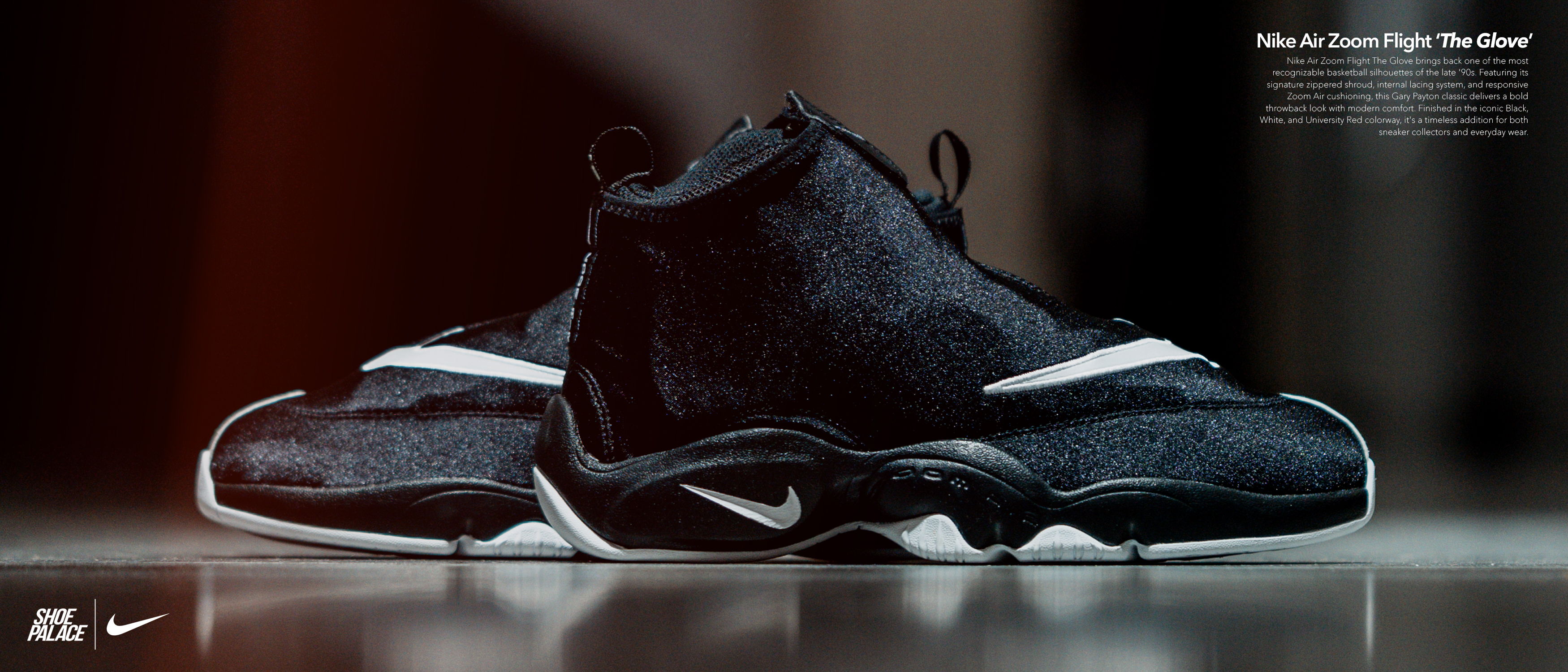 Black Nike sneakers displayed on a reflective surface with a blurred background.