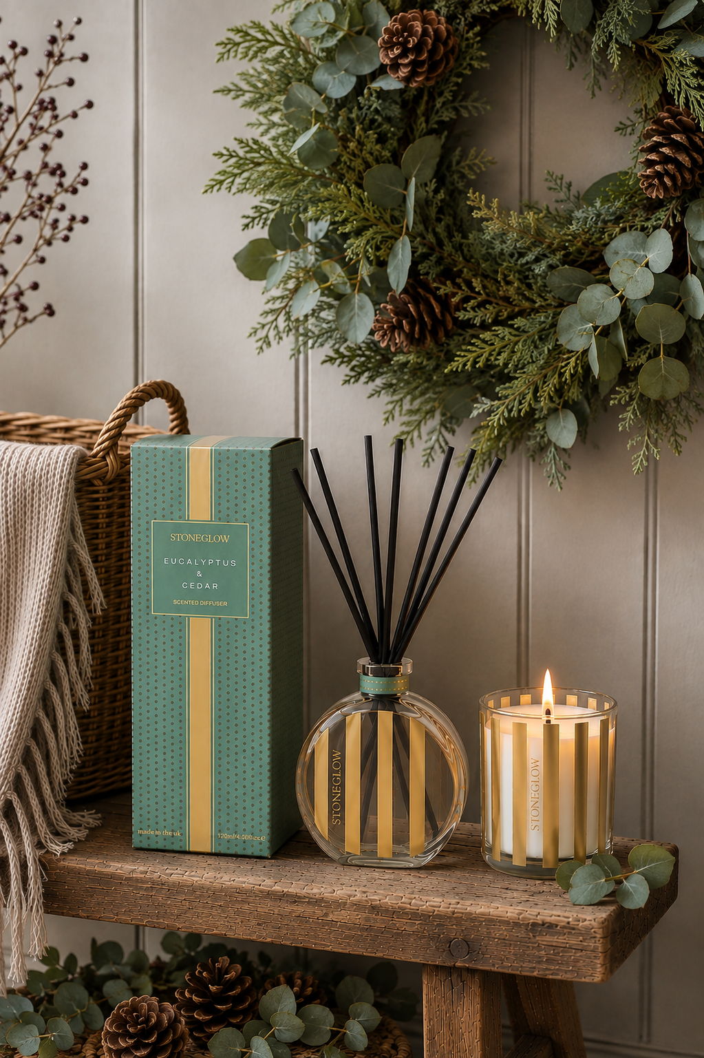 A decorative arrangement with a diffuser, candle, and a wreath.