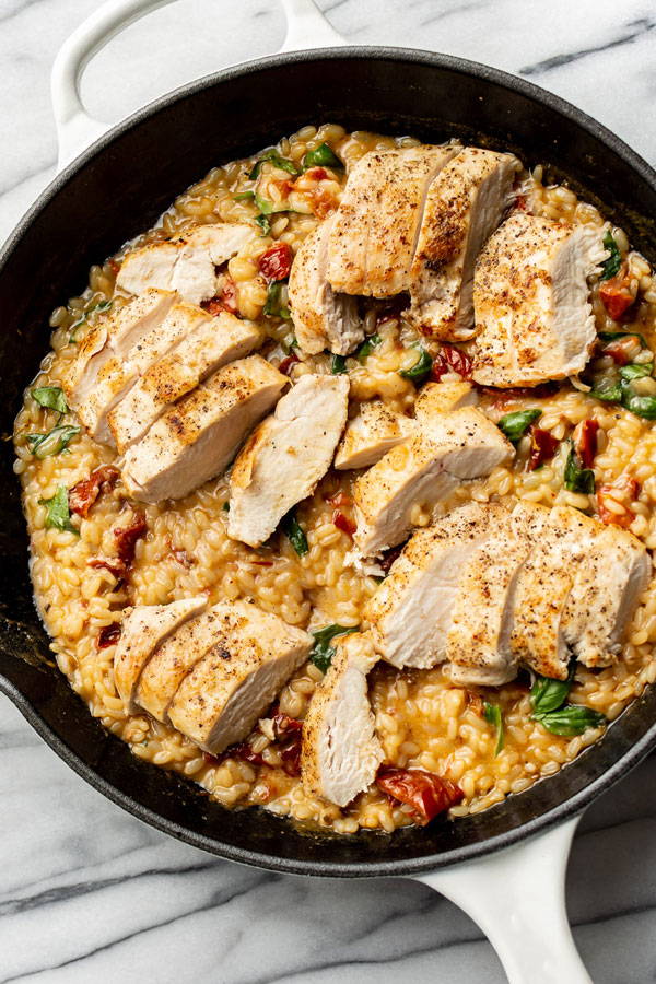 Creamy cheesy risotto with chicken prepared in a pan