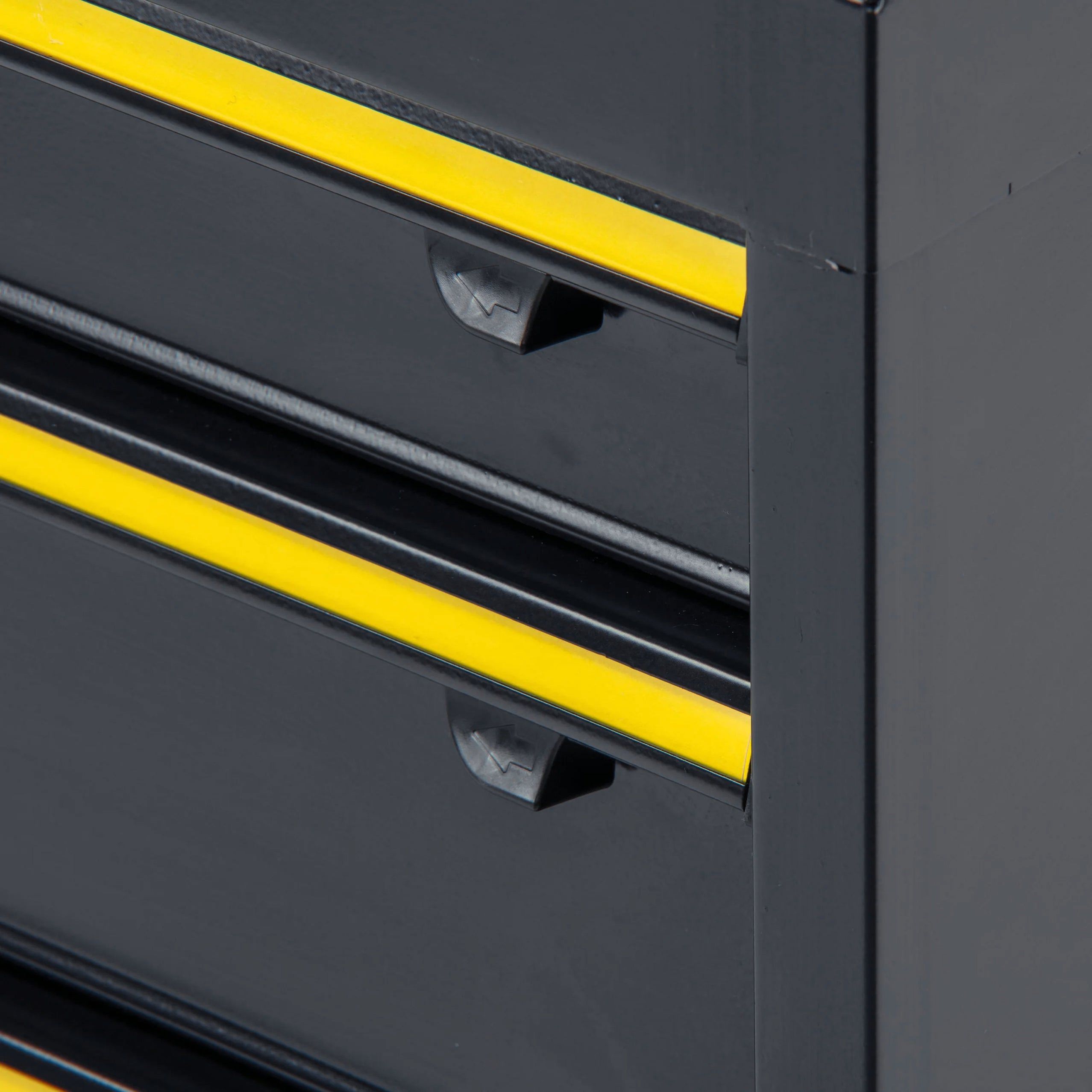 Close-up of a black tool cabinet with yellow drawer handles.
