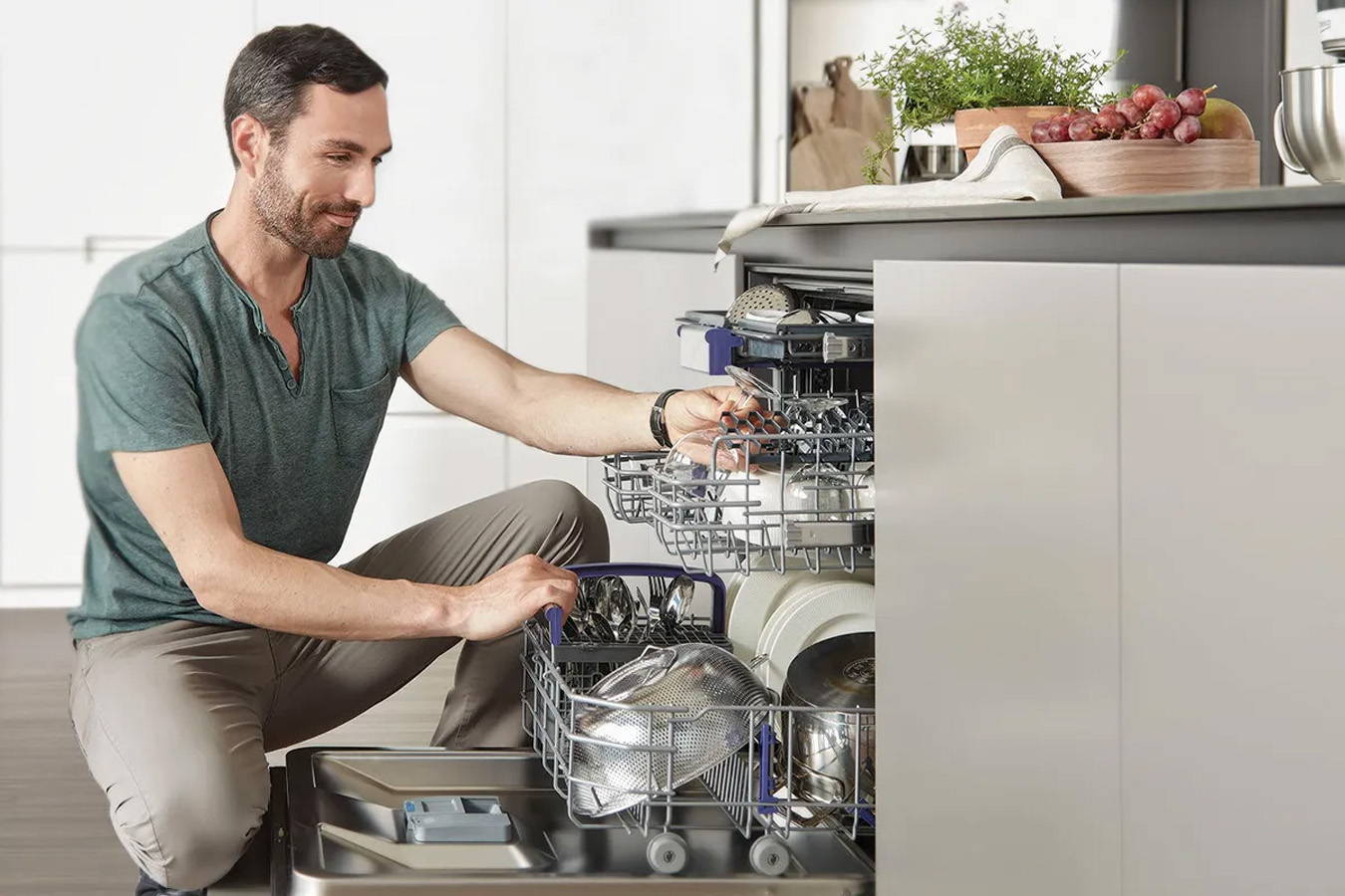 Muž skládající nádobí do myčky