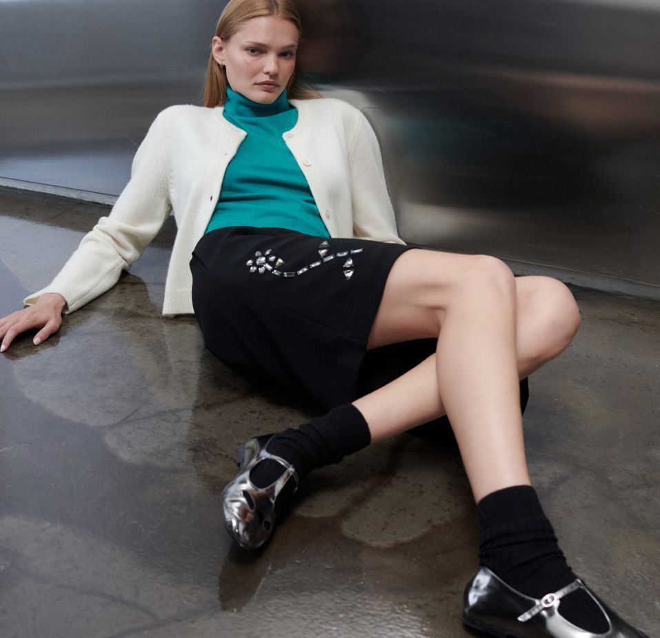 woman laying down, propped up against wall with legs crossed
