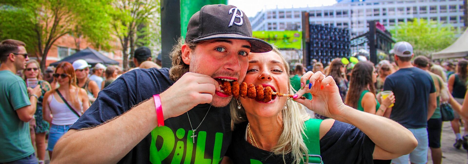 A couple sharing Pickle Me Pete's internet-famous fried pickles at The Big Dill® pickle festival 2025 in Baltimore Maryland