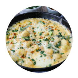 gnocchi in a cheesy sauce served in a cast iron skillet