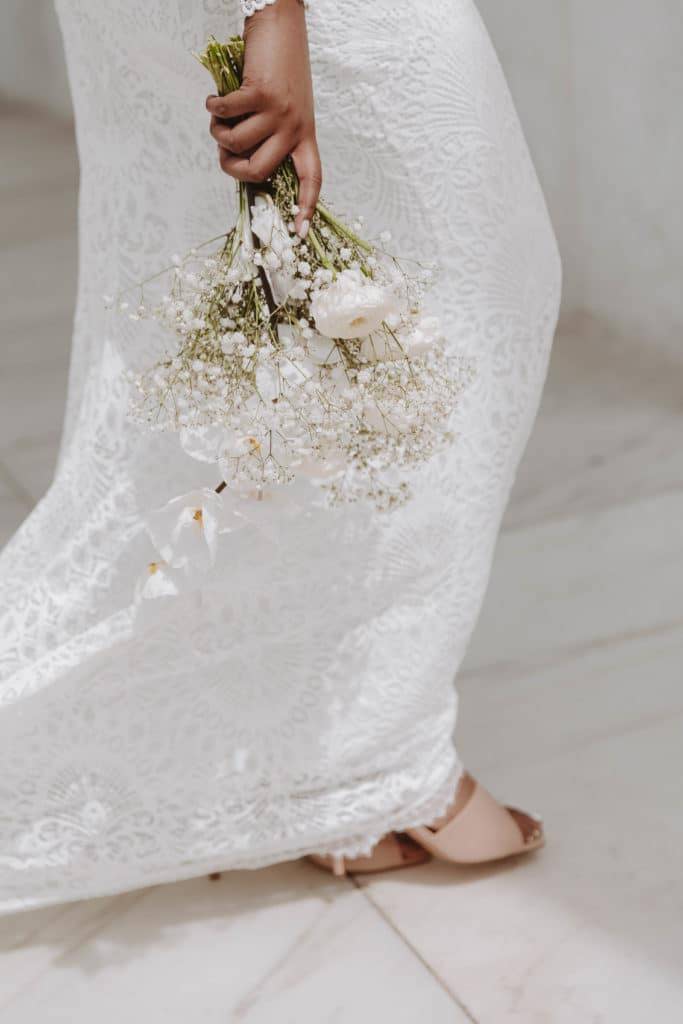 Bride holding simple white floral arrangement