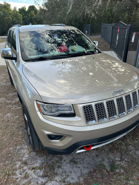 Front three-quarter champagne 2014 Jeep Grand Cherokee WK2 chrome grille seven-slot Jorn's Shocker XL train horns featured customer install gallery photo 1