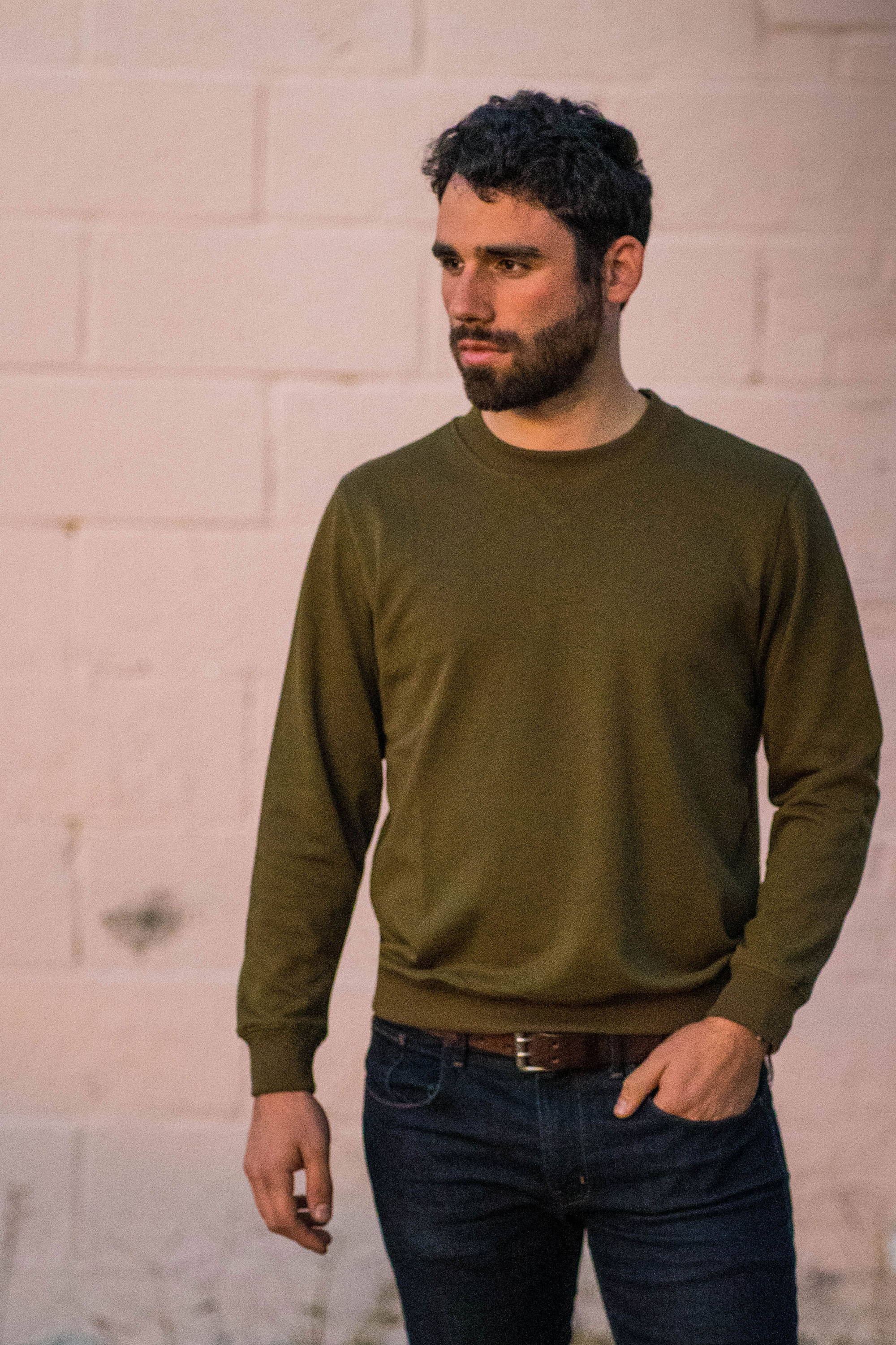 Man standing wearing a green sweatshirt and blue jeans from under510.com