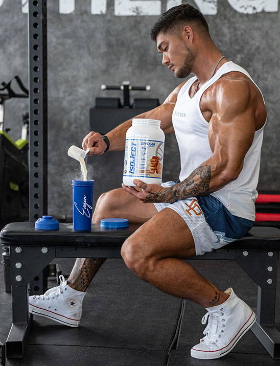 Athlete Nicolas Lee scoops IsoJect out of a can into a shaker in the gym