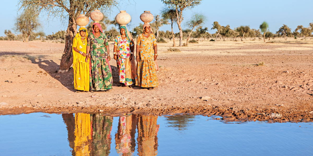 Mulheres em África recolhem água de rios poluídos