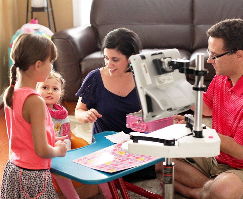Young girl with her family using Tobii Dynavox assistive technology to communicate 