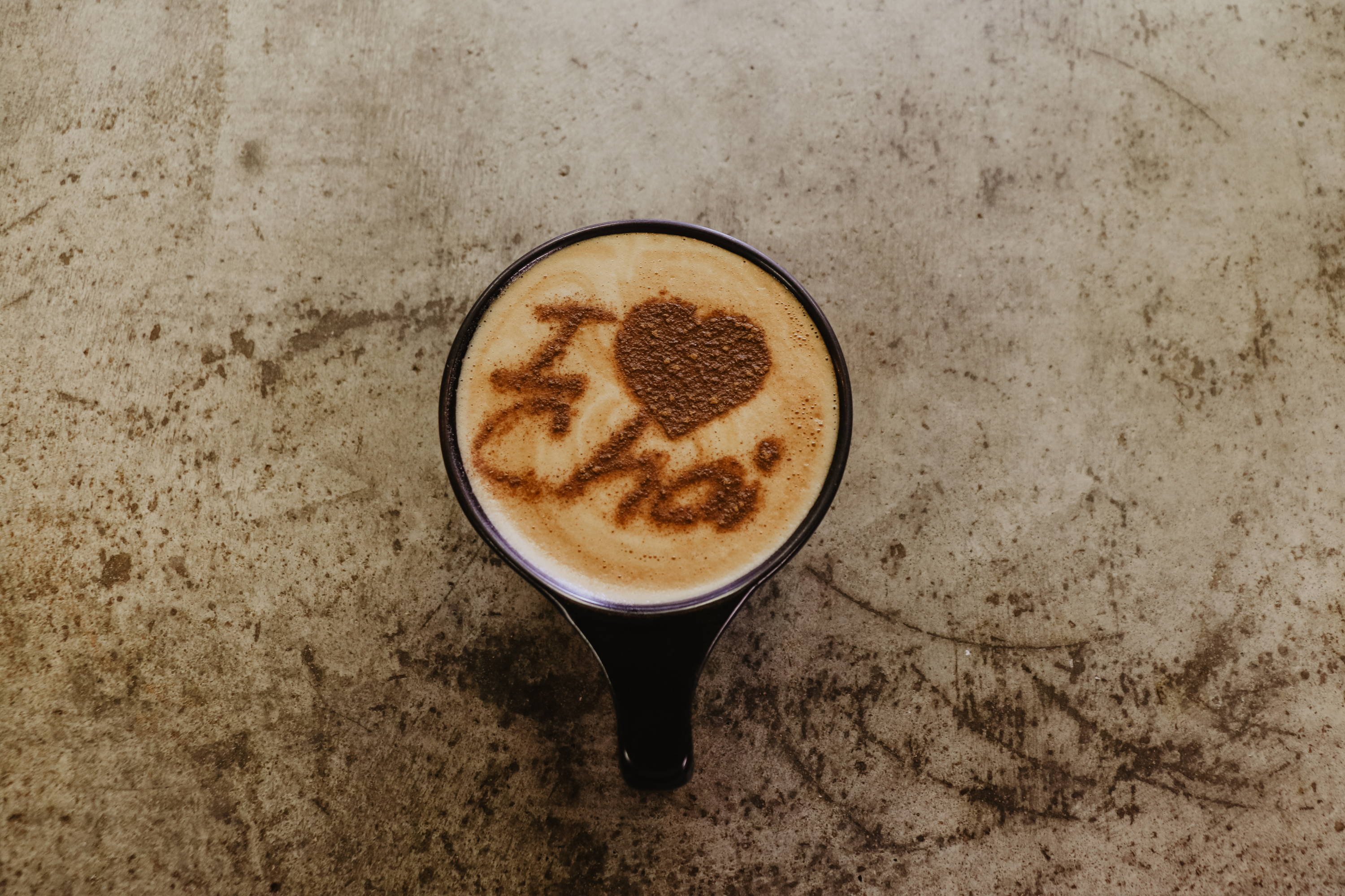 A bird’s eye view of a black cup of chai latte sitting on a countertop