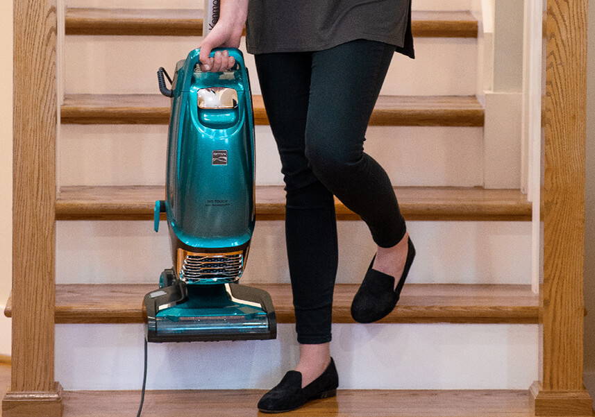 Lightweight Kenmore® vacuum being carried down the stairs