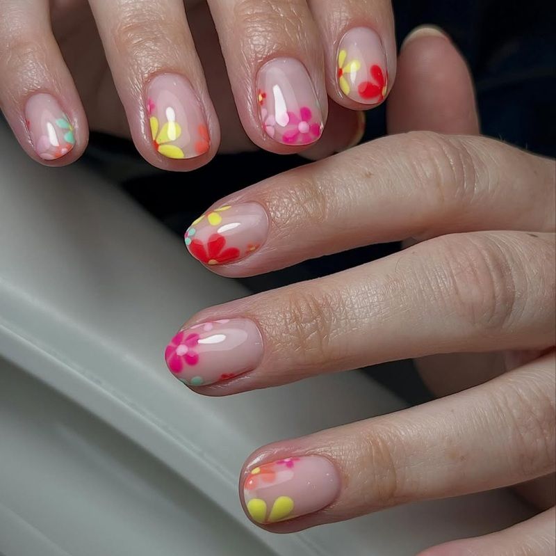 Colorful floral nail art on manicured hands.