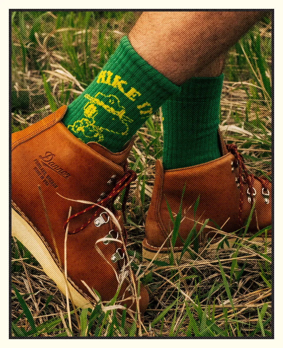 A close-up of brown boots and green socks in grass.