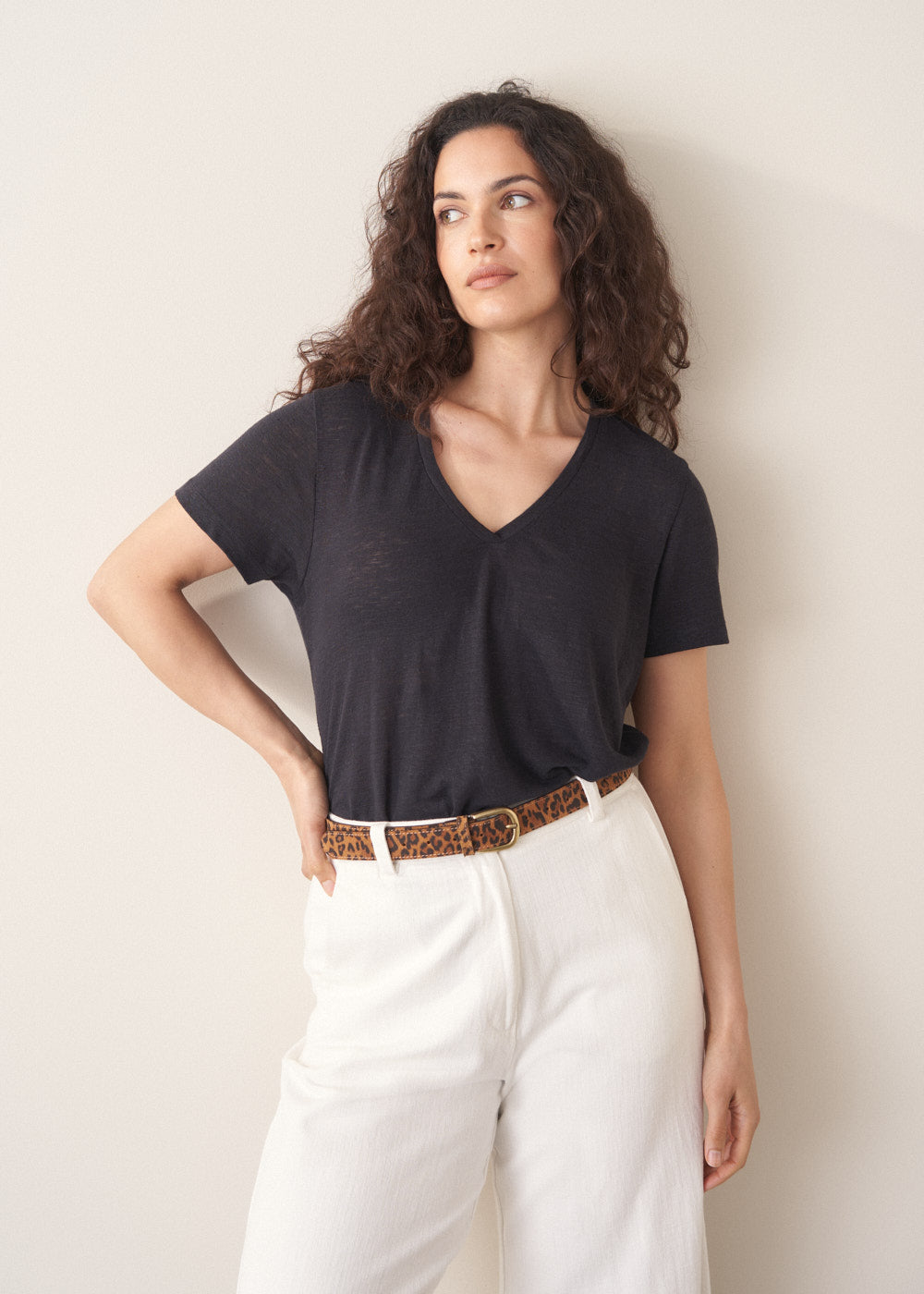 Woman wearing dark grey linen v-neck t-shirt and white jeans