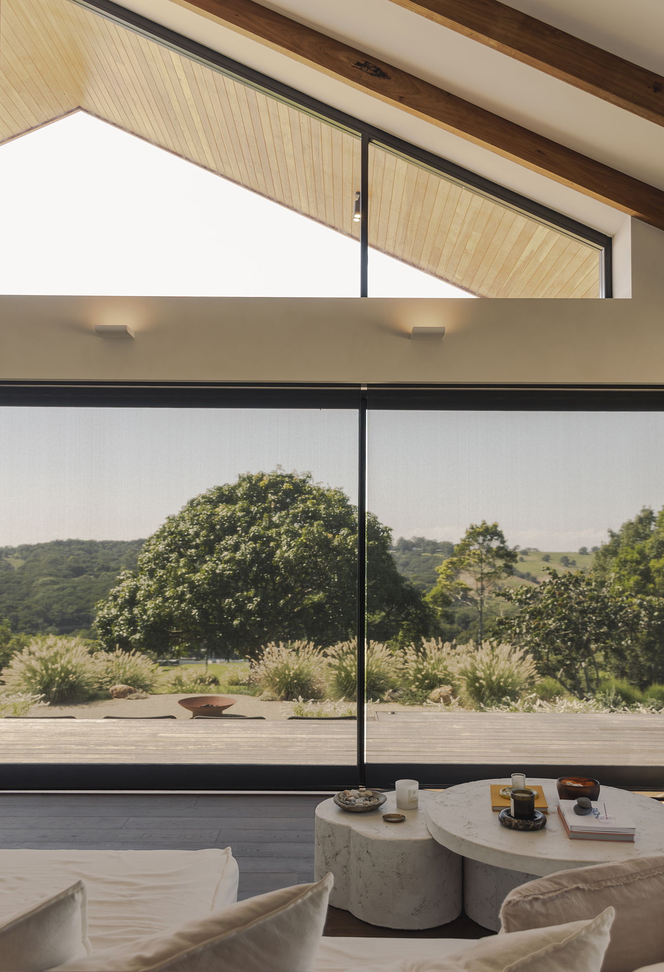 Modern interior with large windows overlooking a lush green landscape.