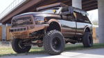 Lifted two-tone brown and copper Ram Copperhead truck with Wicked Bumpers grille parked under bridge