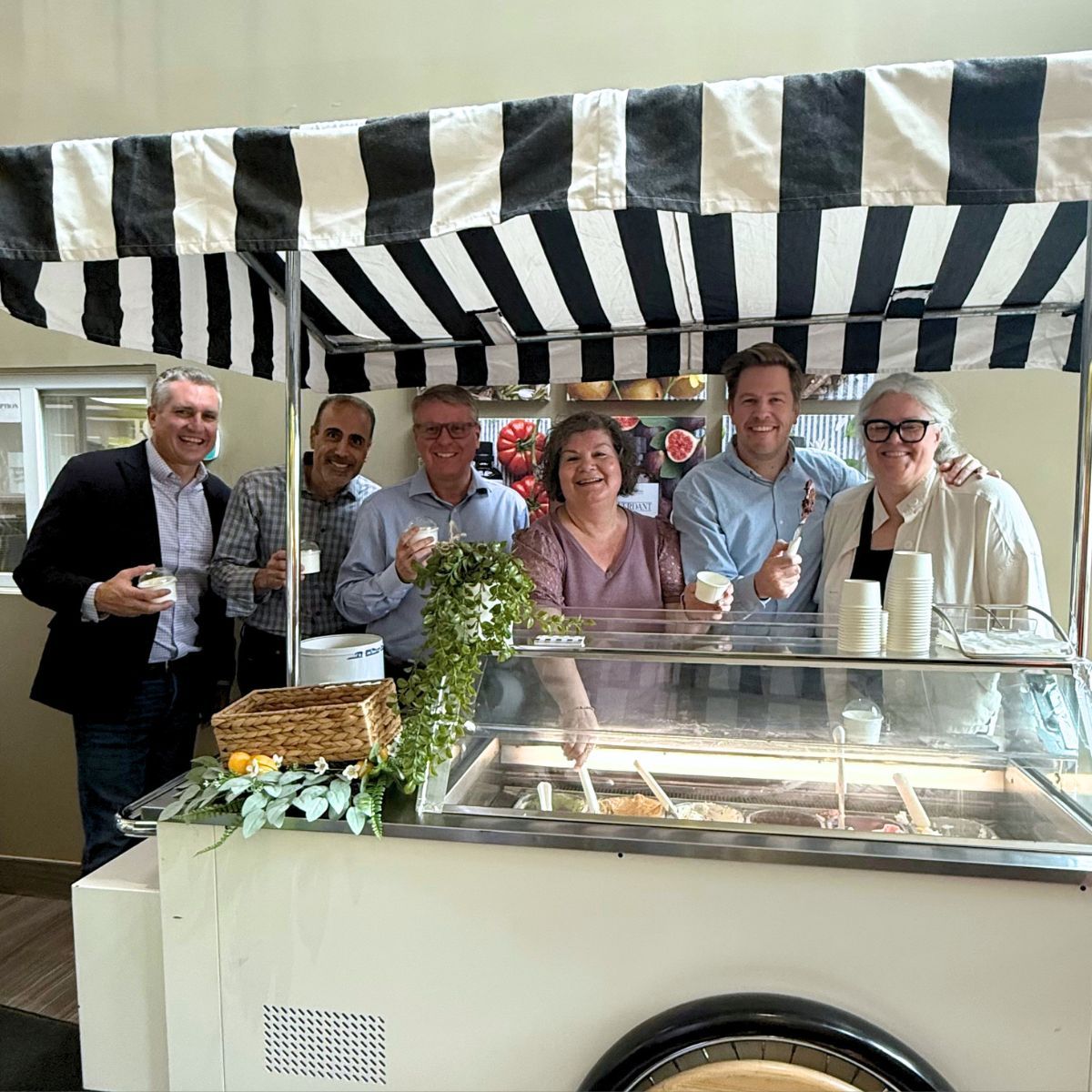 Group of people enjoying ice cream at a vendor cart.