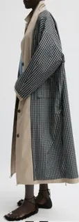 A side view of a model wearing a stylish, patterned coat.