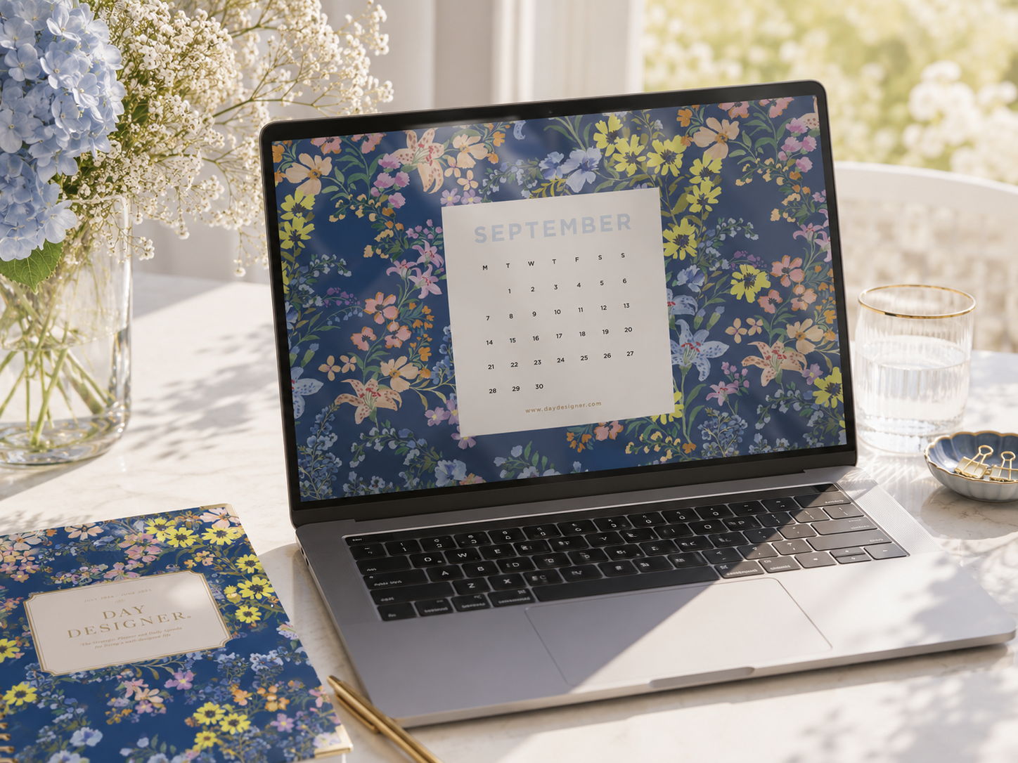 september 2026 digital wallpaper shown on laptop, desk with floral planner, vase with flowers, dish, paperclips