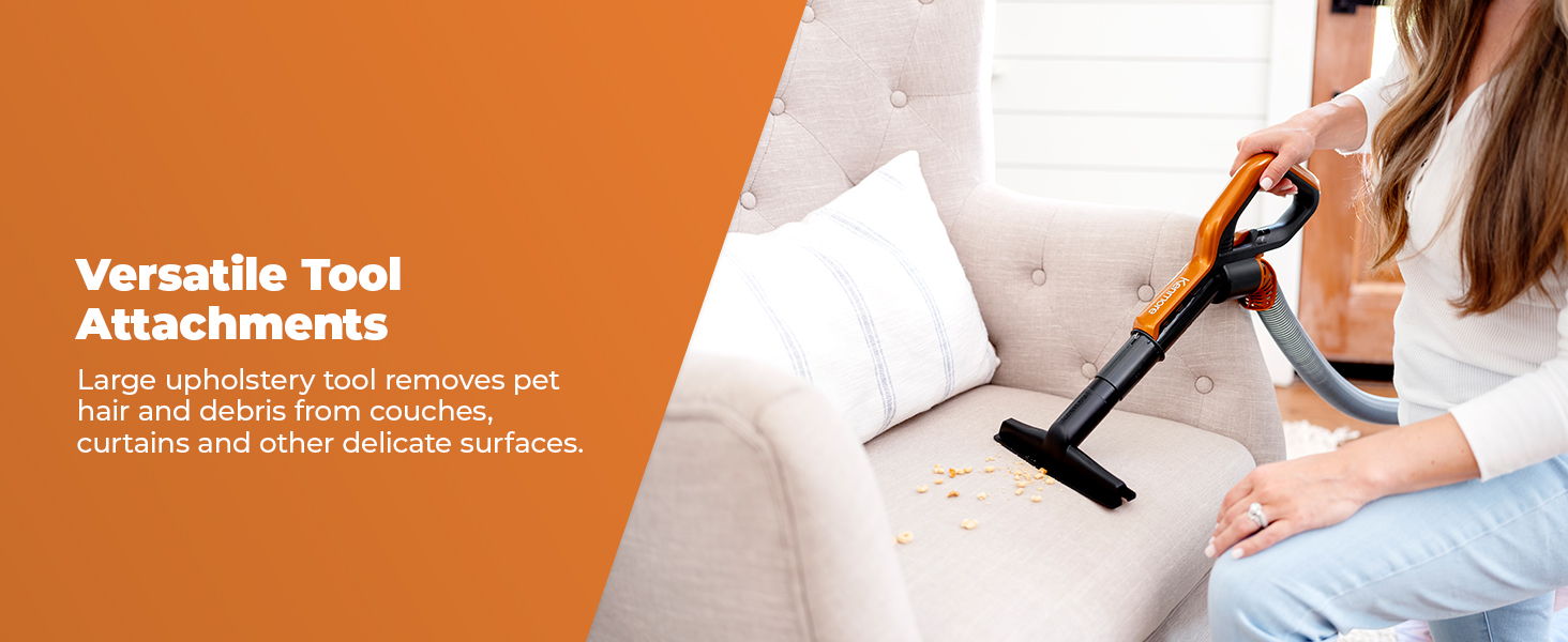Person using a vacuum cleaner attachment on a couch.