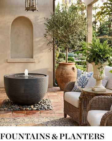 Outdoor space with a fountain, planters, and comfortable seating.