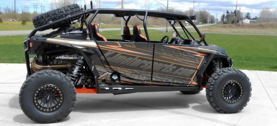Side profile black orange KJmotorsports.com Polaris RZR four-seater roll cage spare tire beadlock wheels Conductor's Special 244 Nightmare Edition train horn kit featured customer install gallery photo 1
