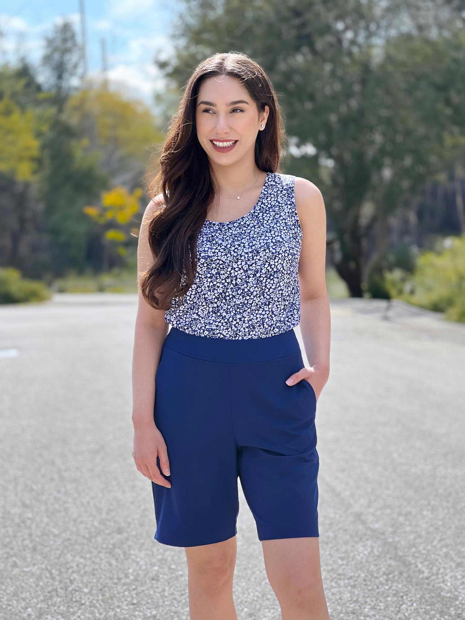 Woman standing wearing Miik's Irelynn bermuda pocket short in royal blue with a blue ditsy top.