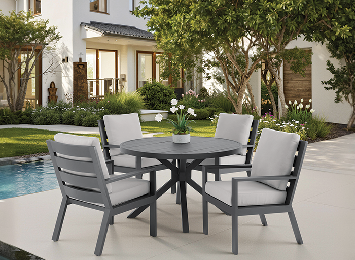 Outdoor dining set with round table and four chairs next to a pool.