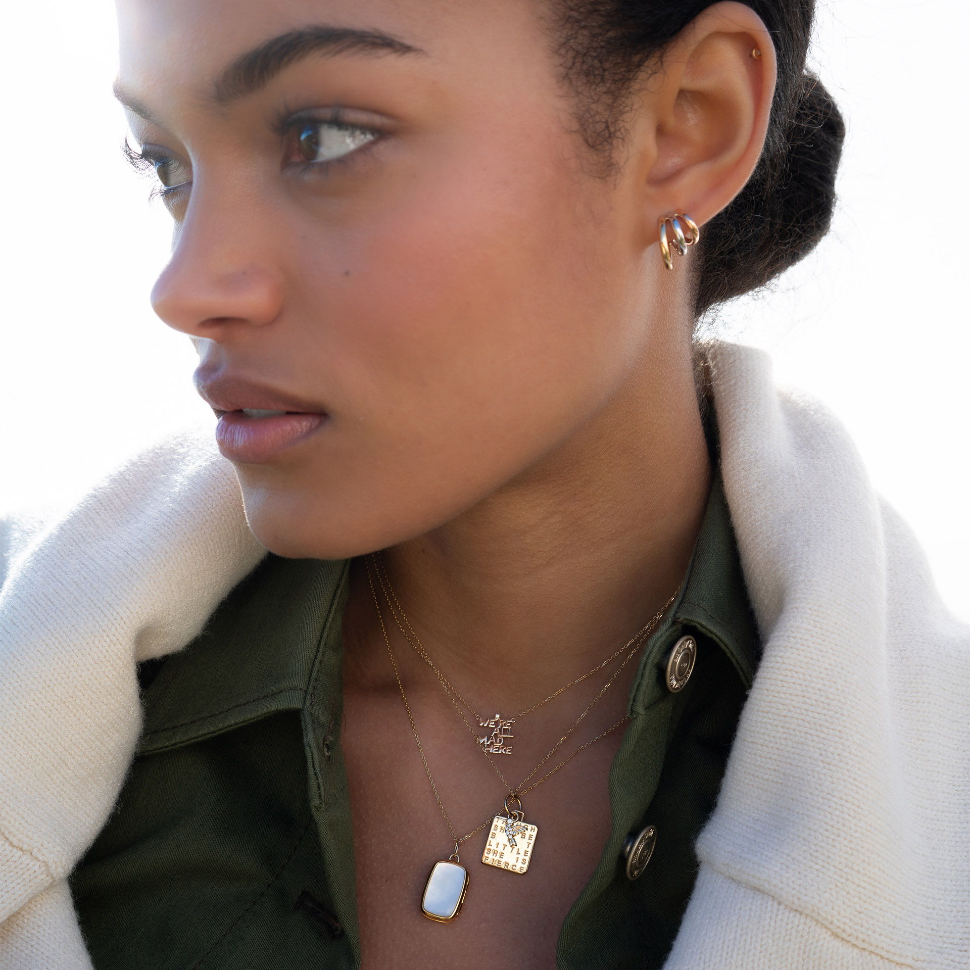 Profile of a woman wearing jewelry and a stylish coat.