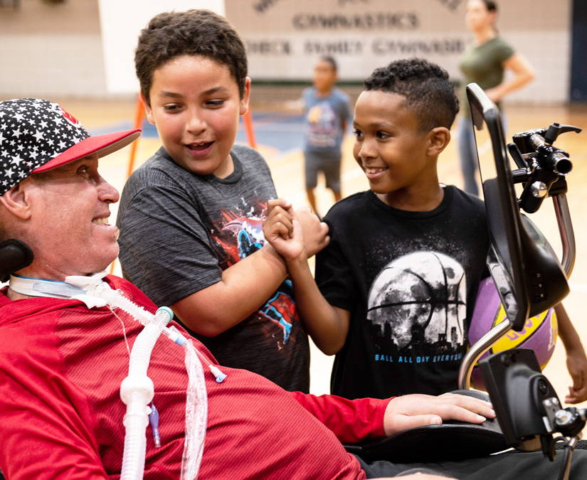 Man coaching a basketball team with help of his Tobii Dynavox I-Series device 