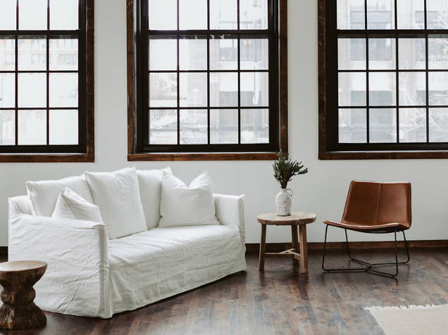 White linen couch inside the Grace Loves Lace bridal showroom in Chicago