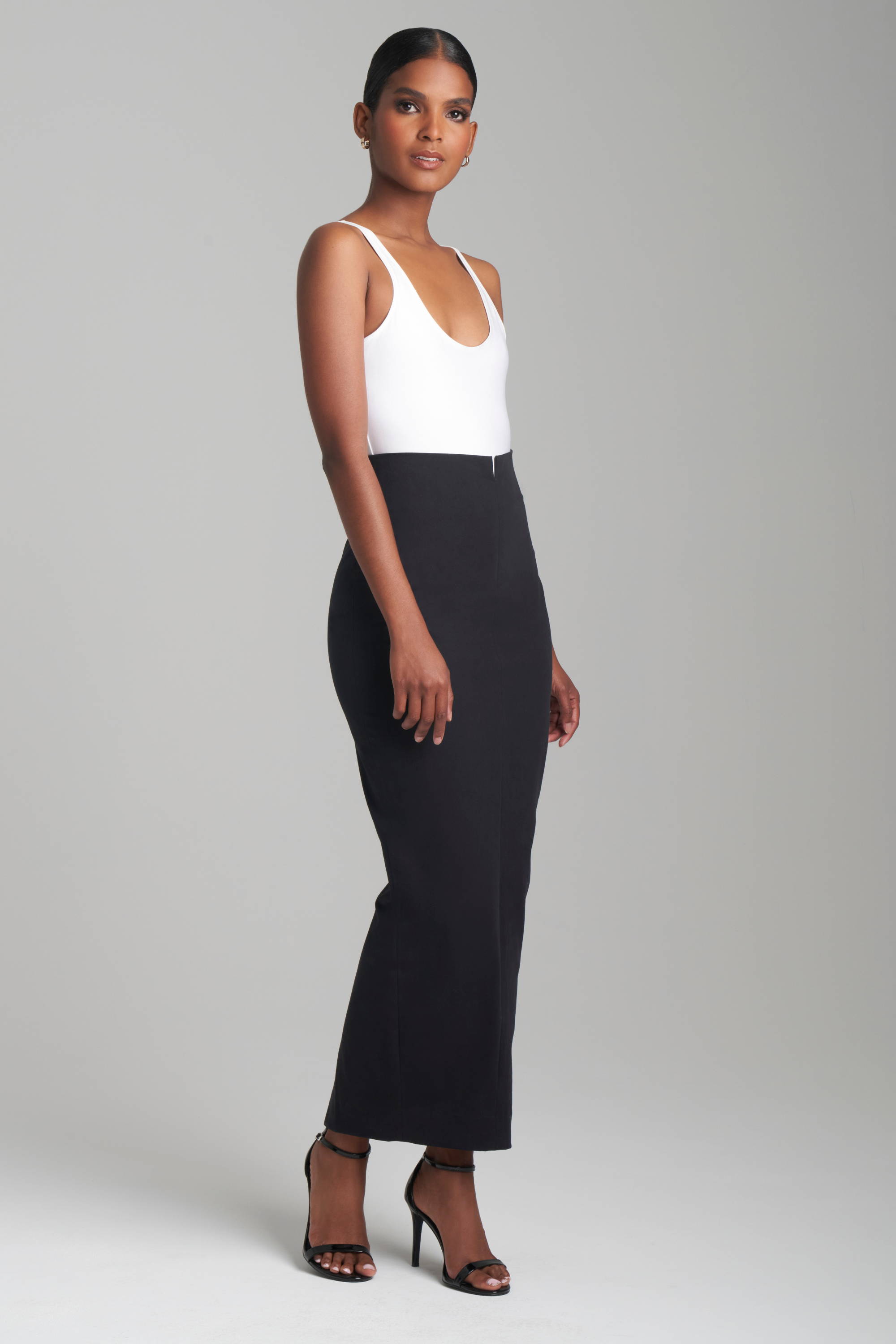 Woman wearing black stretch cotton pencil skirt with white tank top by Ala von Auersperg