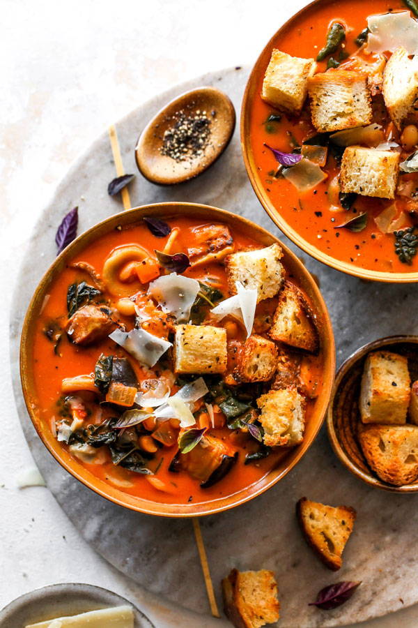 A tomato based soup featuring eggplant, garlic croutons, and parmesan cheese.