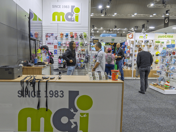 Trade show booth with people browsing products and a logo display.