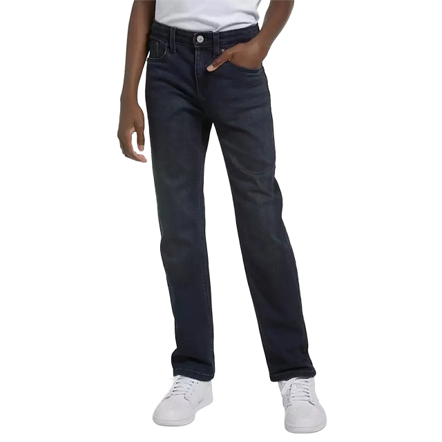 Child wearing dark jeans and white sneakers, standing with one hand in pocket.