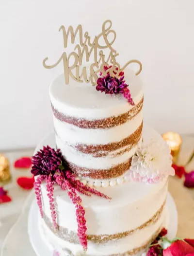 White layered wedding cake with purple and pink flowers