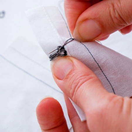 Sew a buttonhole stitch to secure the hook in place