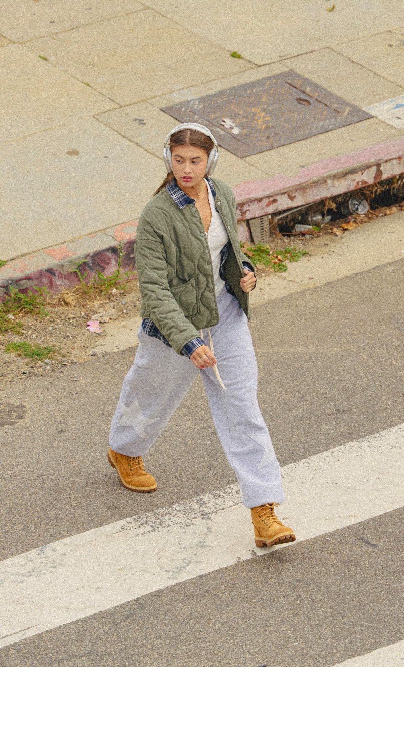 Person walking in casual outfit on a city street.